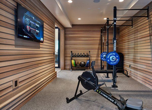 home gym with concept2 rowing machine, rogue power rack, and tv